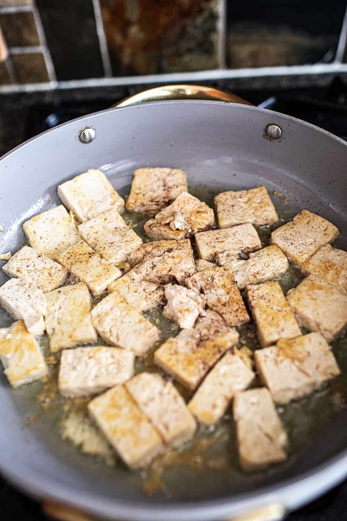 Crispy tofu in a pan on the stove. 