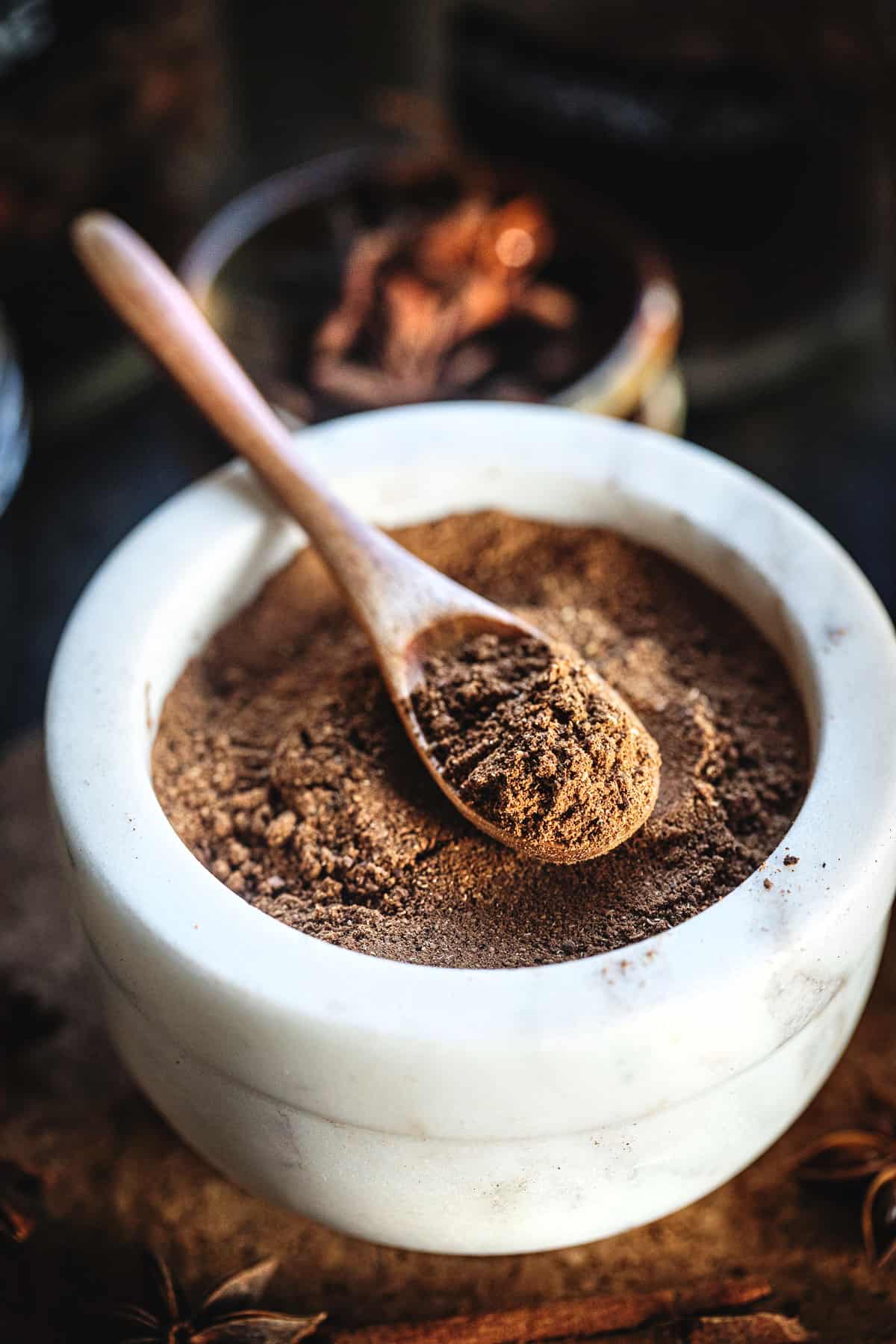 spoon holding five spice powder in a bowl. 