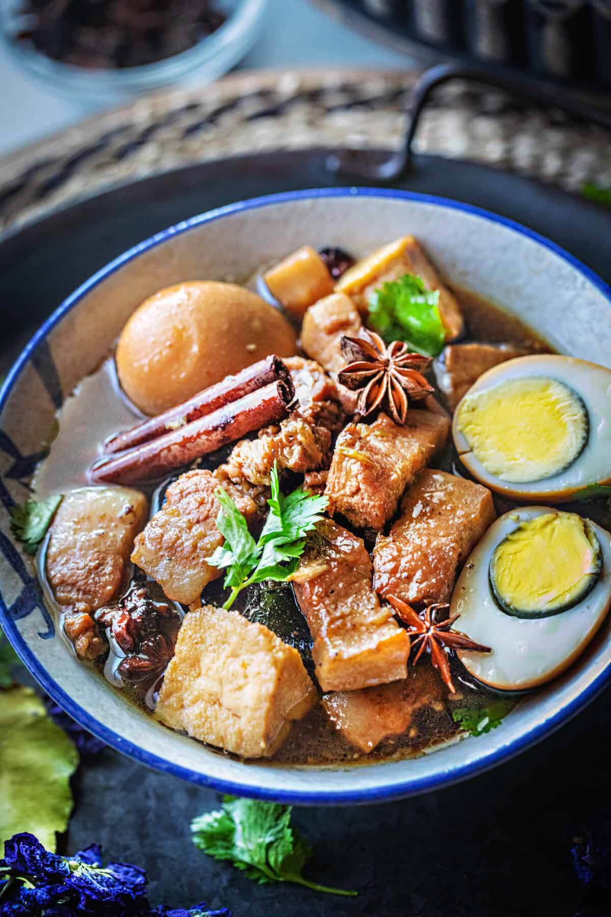 Pork belly stewed with sliceds eggs in a bowl.