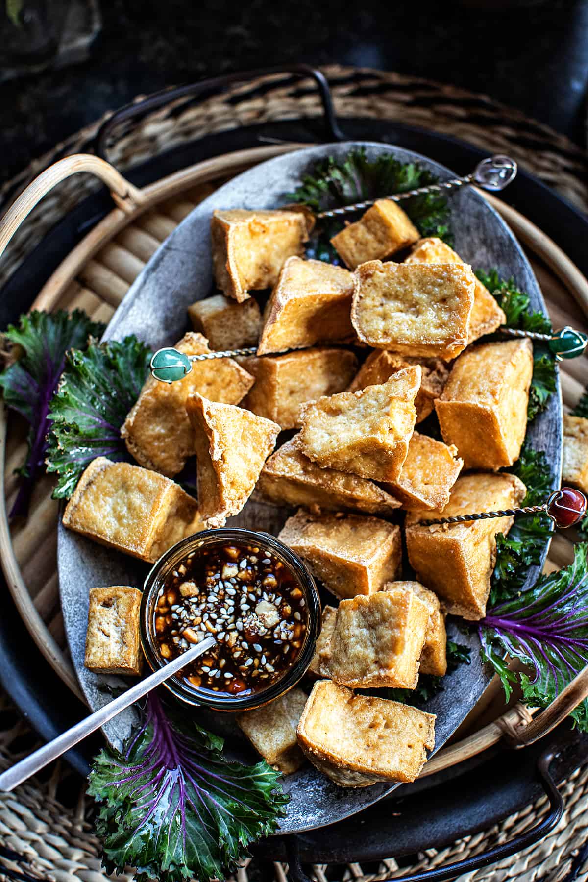 Fried tofu puffs on a plate with diping sauce. 