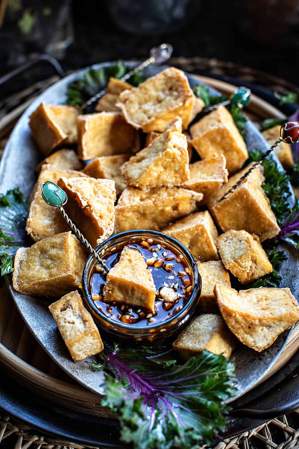 puff tofu on a plate with dipping sauce on the side. 