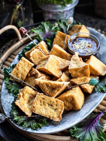 puffed tofu on palate with dipping sauce.