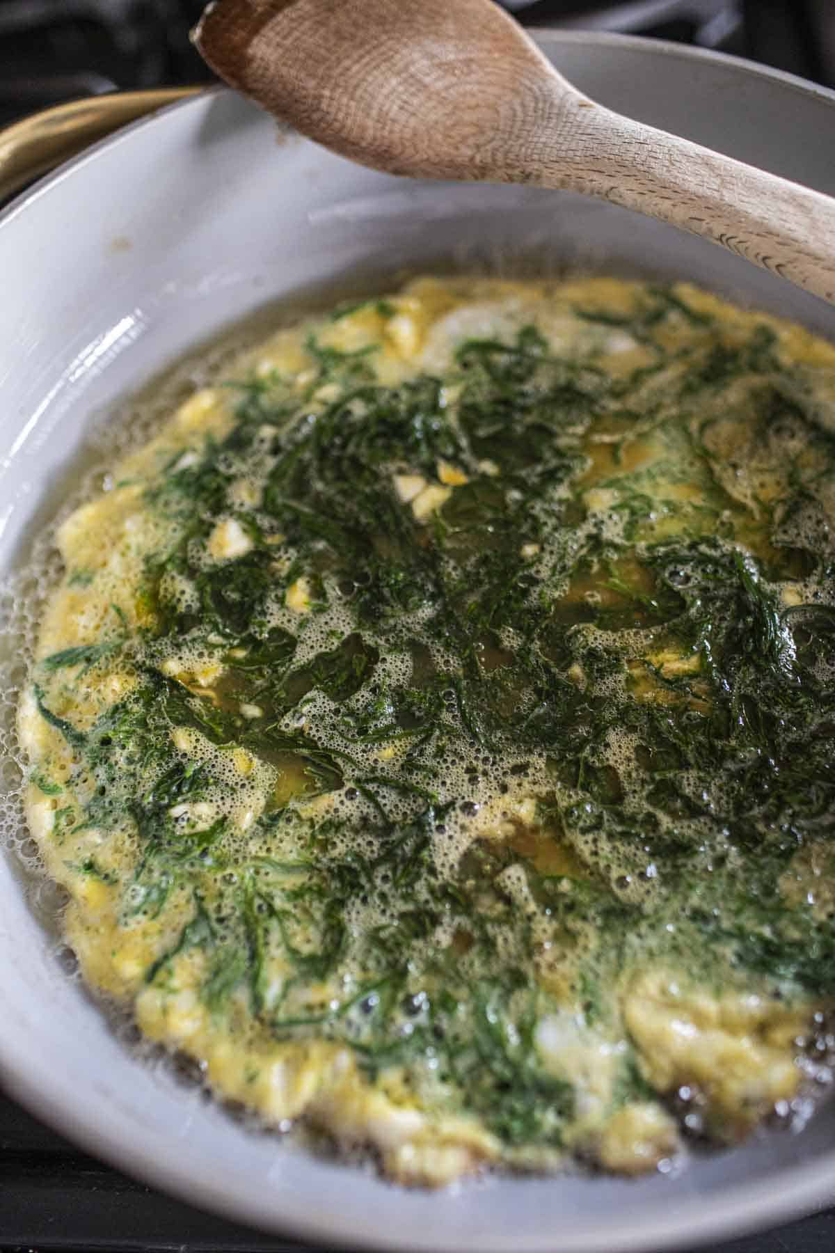 Fried Cha Om Omelete in a pan on the stove. 