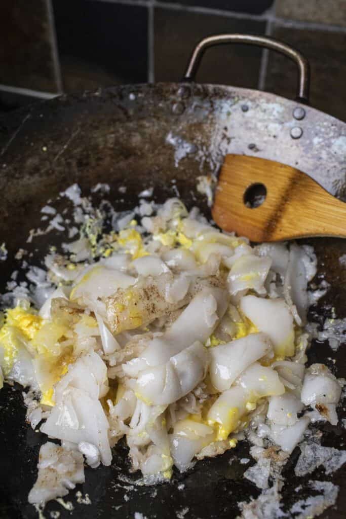 Guay Tiew Kua Gai with wide noodles in a wok. 