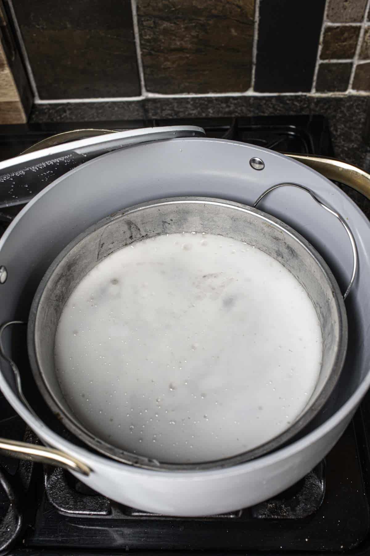 white rice noodles in around pan inside a steamer on the stove.