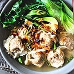 Thai wonton soup in a bowl with bok choy.