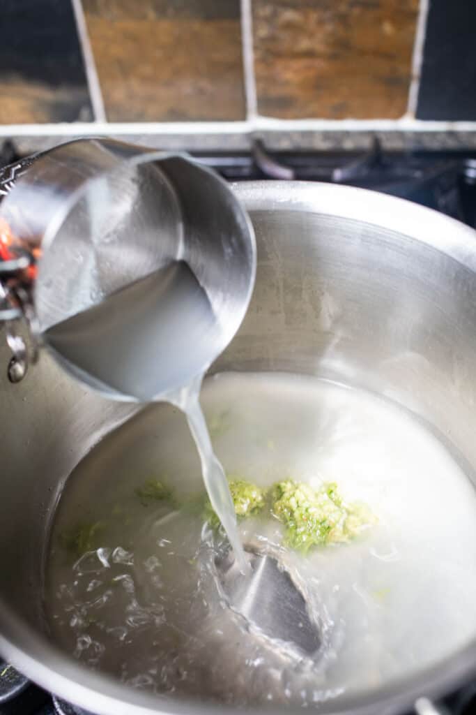 Measuring cup Pouring stock into a soup pot. 