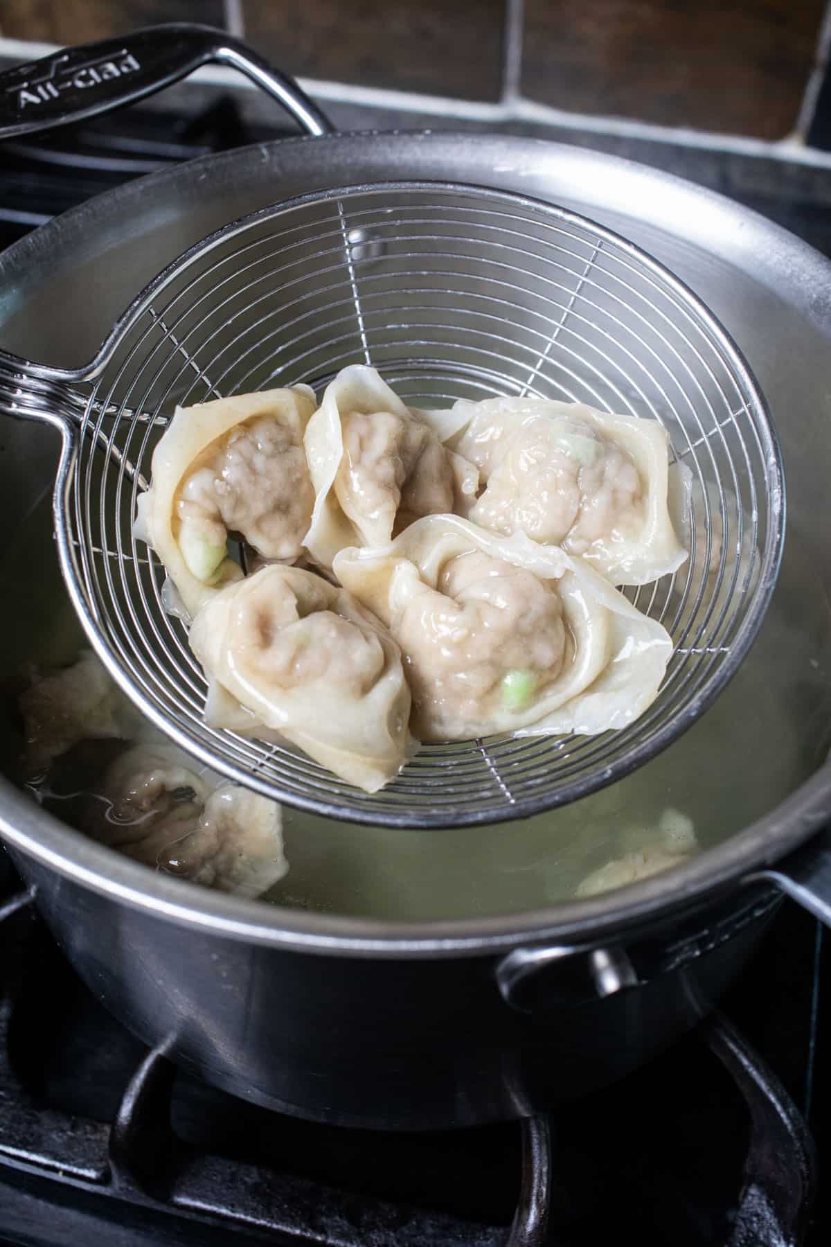 A wireless lifting wontons from a pot. 