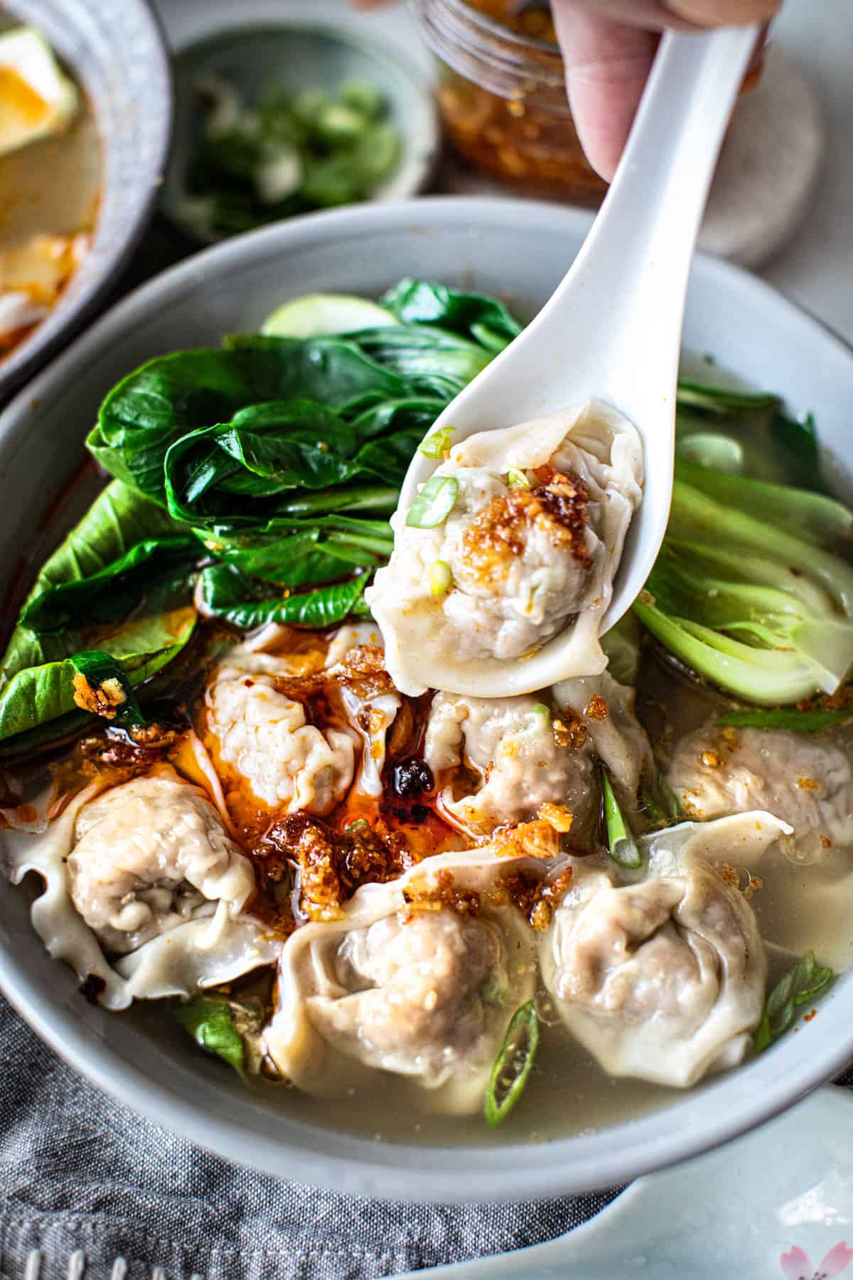 Thai wonton soup recipe with a spoon in bowl.
