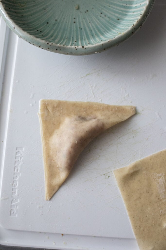 Triangular wonton on the cutting board. 