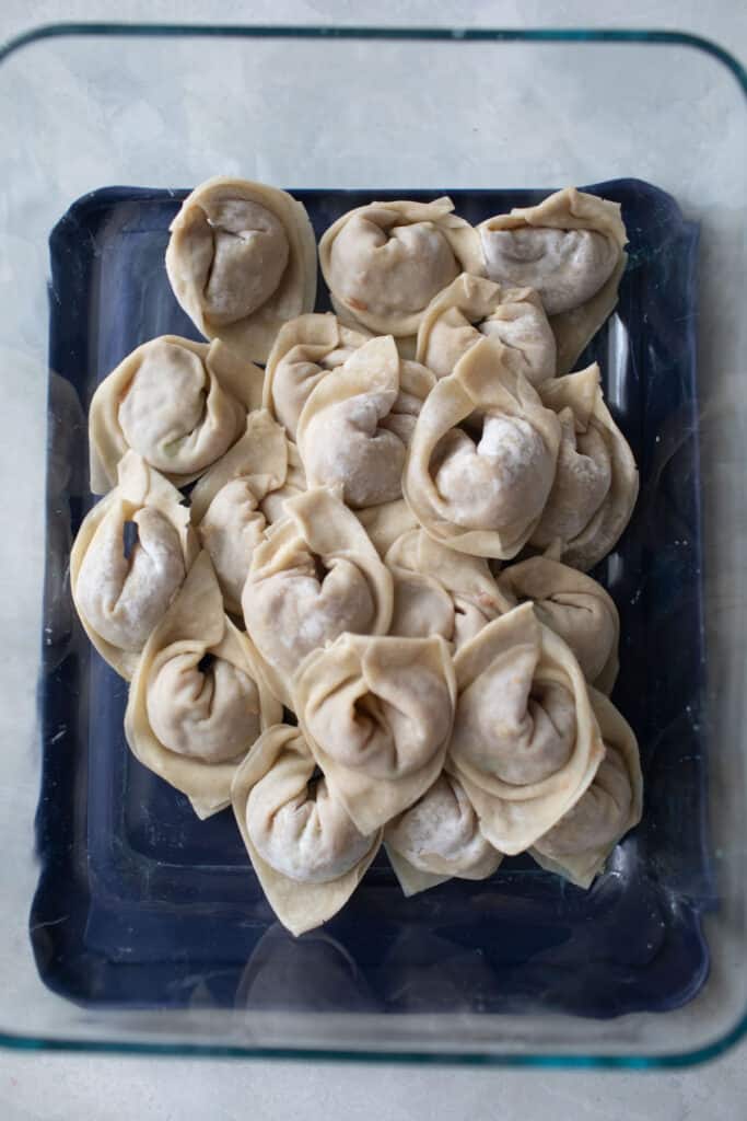 Boat shaped wontons in a container.