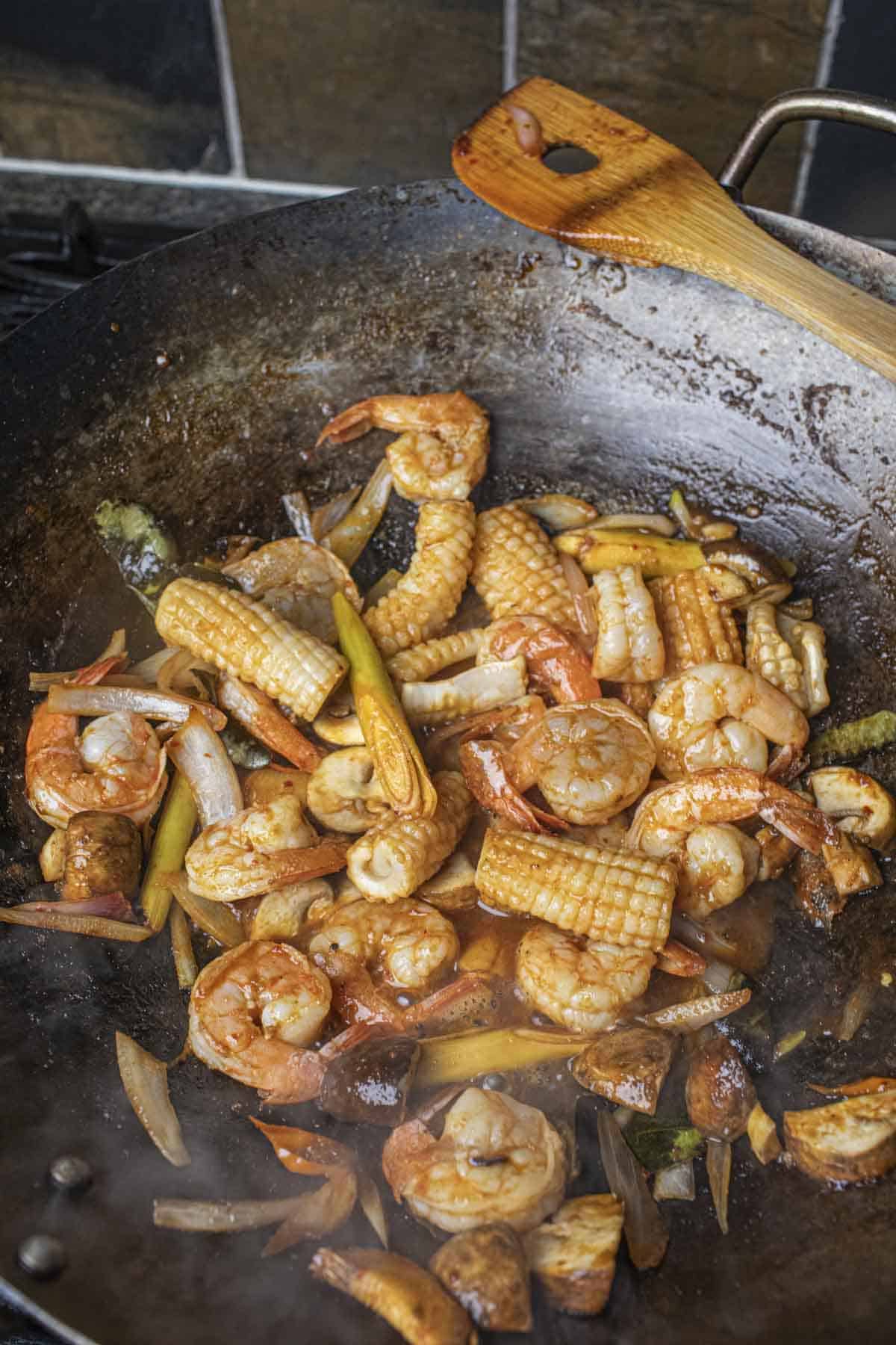 Shrimp and squid with tom yum sauce in a wok. 