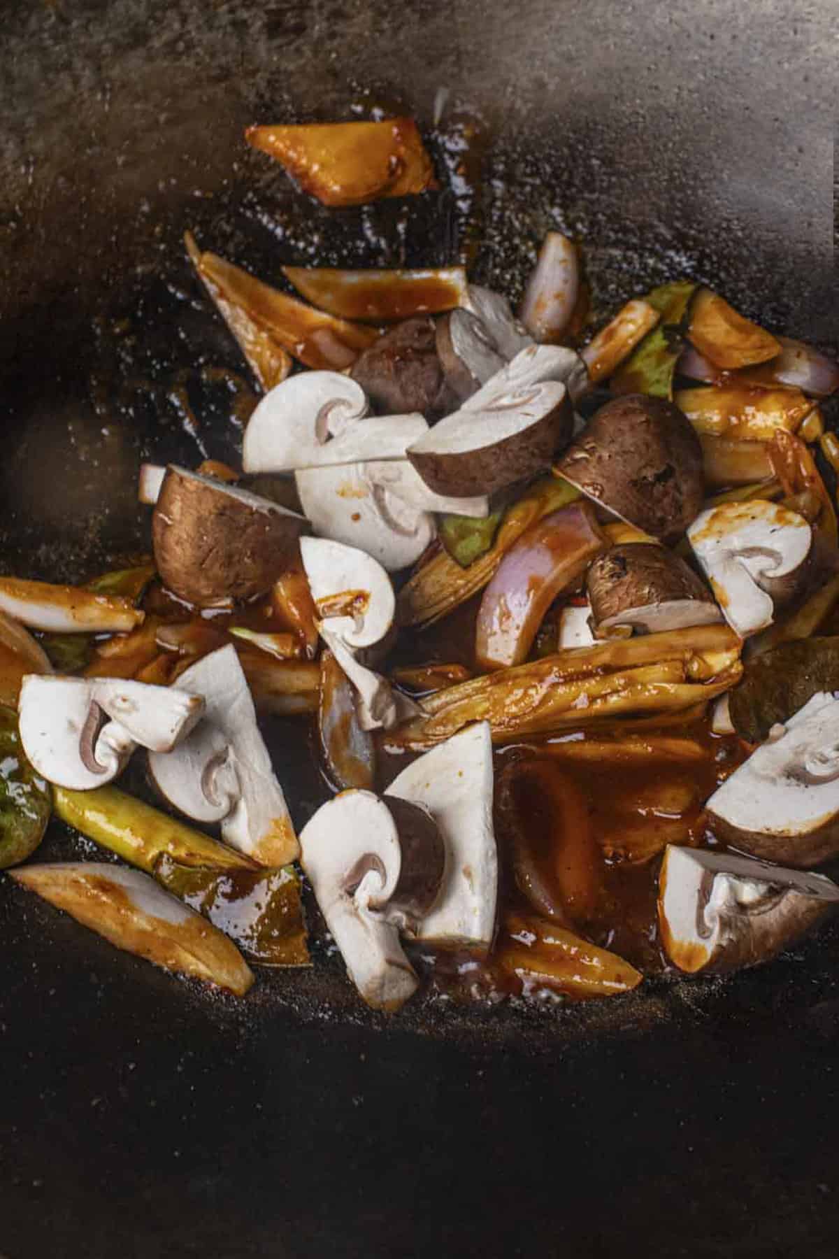 Herbs and veggies with tom yum sauce in a wok. 