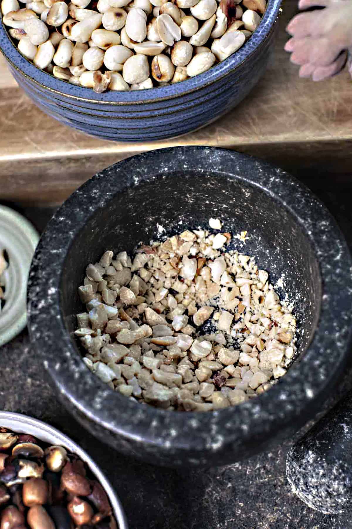 Lightly crushed peanuts in a mortar.