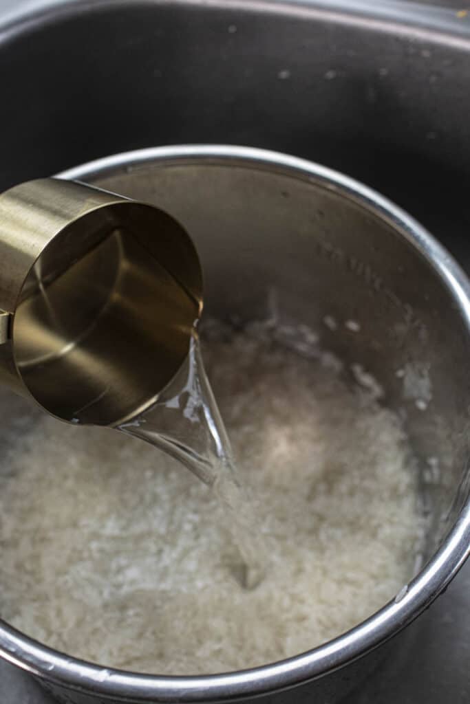 water pouring into Instant pot in a sink. 