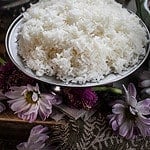 cooked jasmine rice on a silver platter on the table.