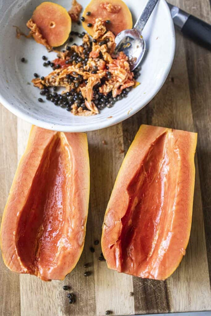 ripe Papaya halves on a cutting board. 