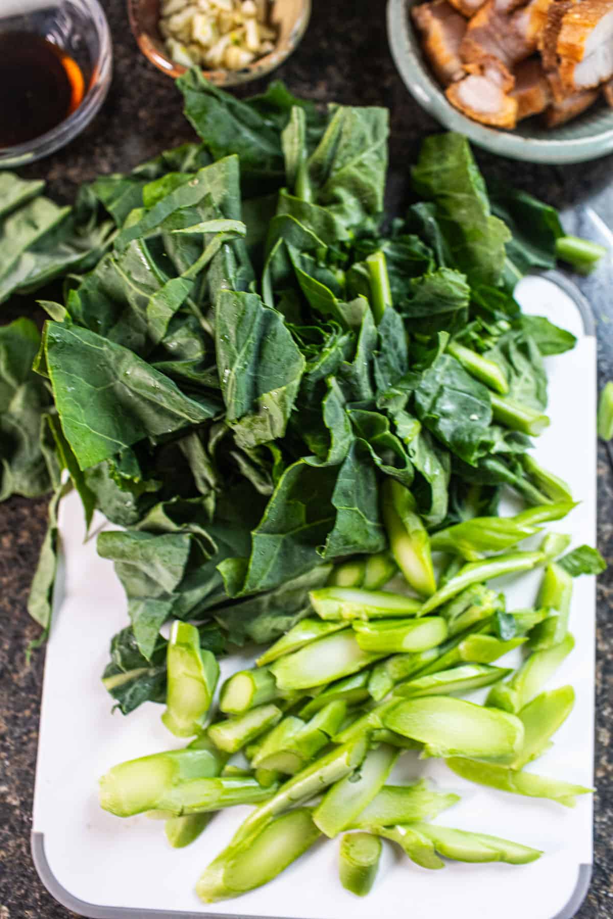 Chopped Chinese broccoli on a cutting board on the counter. 