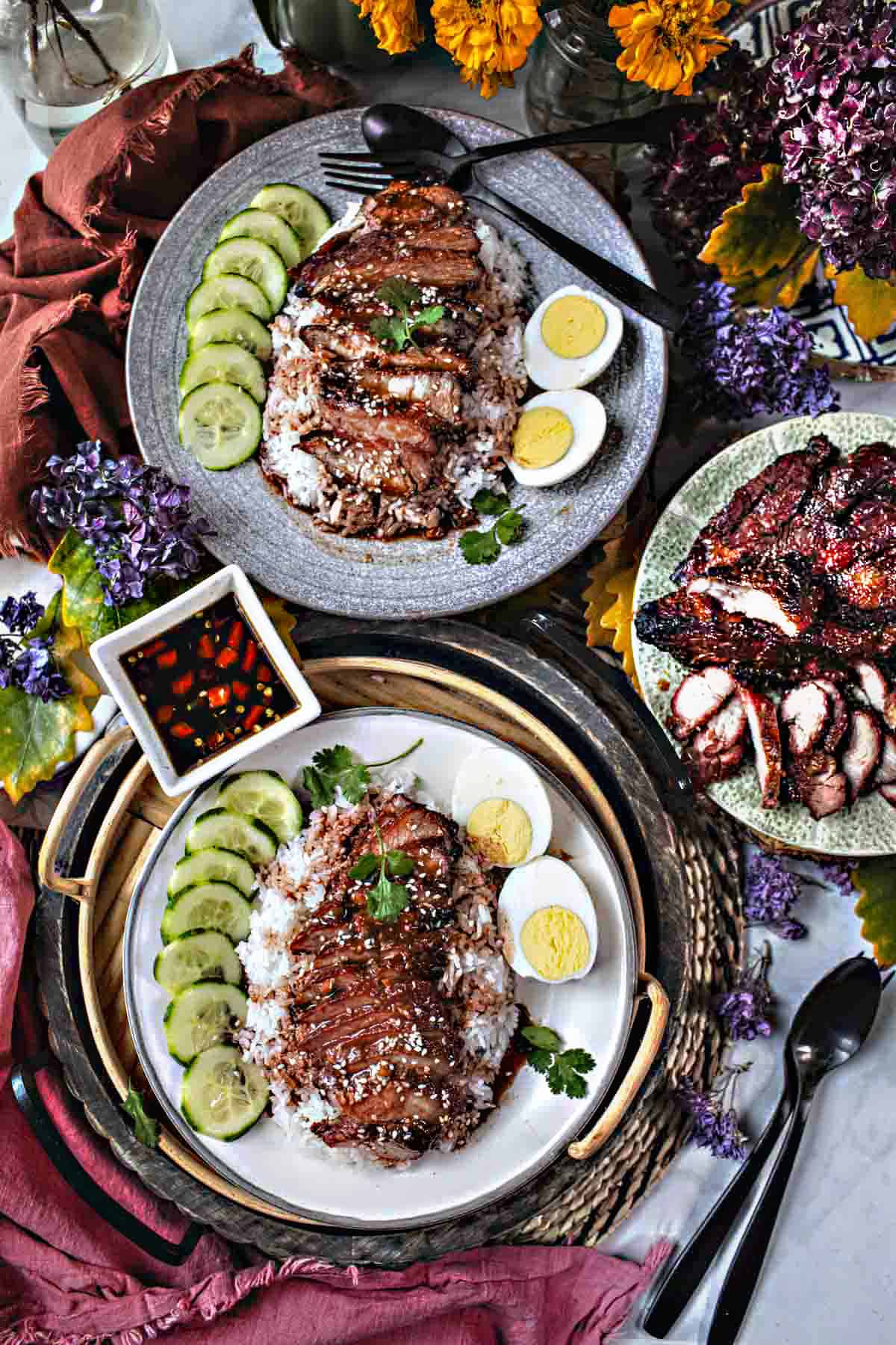 2 plates of Thai Kao Moo Dang on the table.