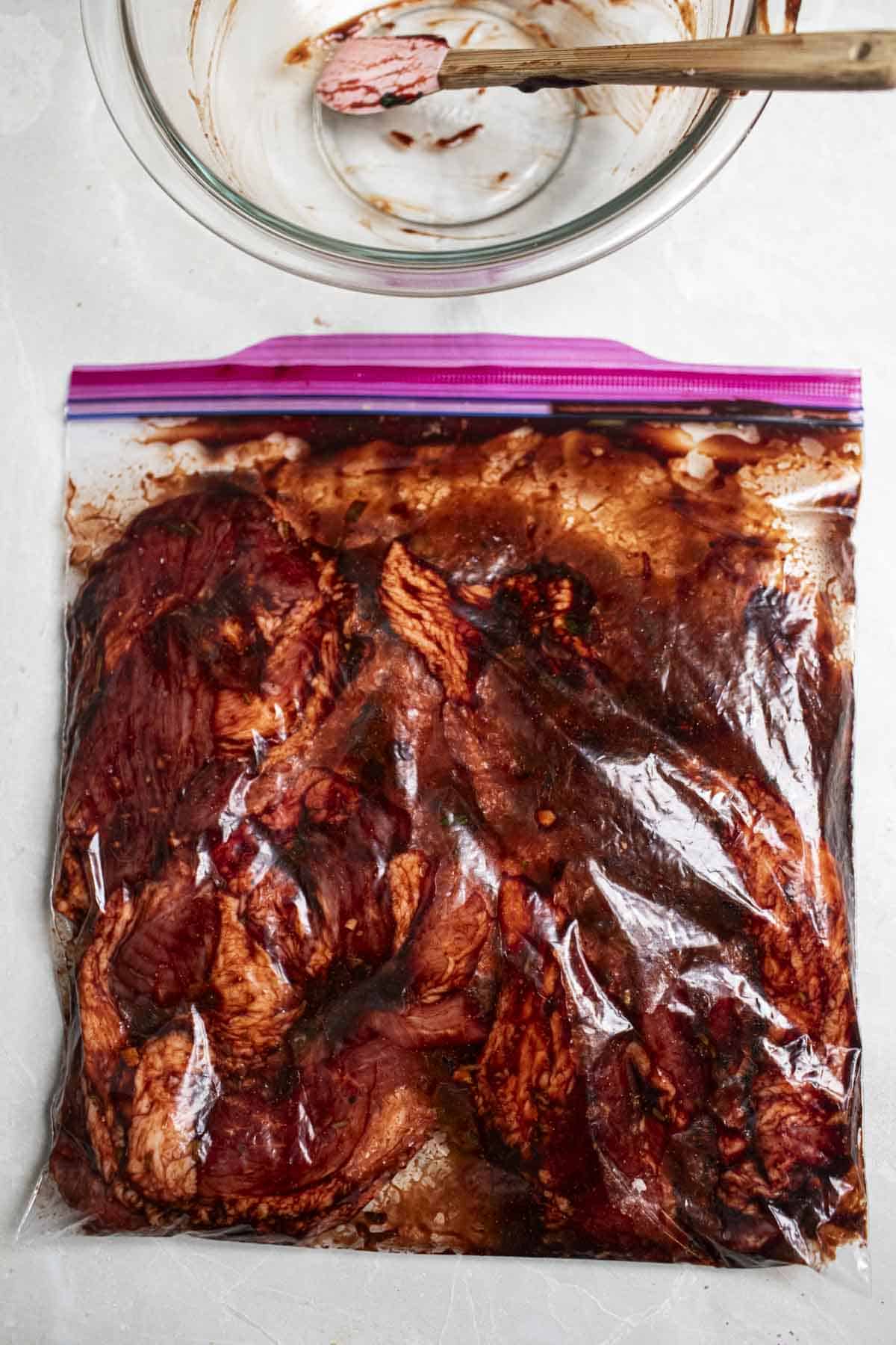 red pork slices marinated in ziplock bag.