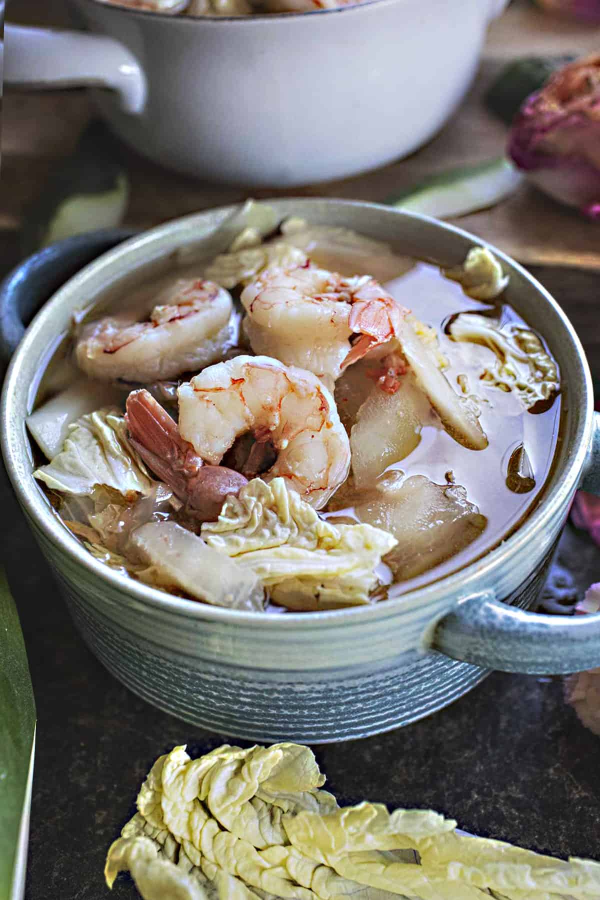 Green papaya soup with shrimp in a bowl on the table.