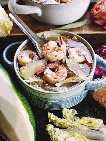 Papaya soup with shrimp in a bowl on the table.