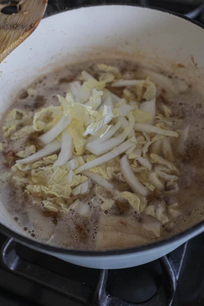 Sliced cabbage in a soup pot on the stove. 