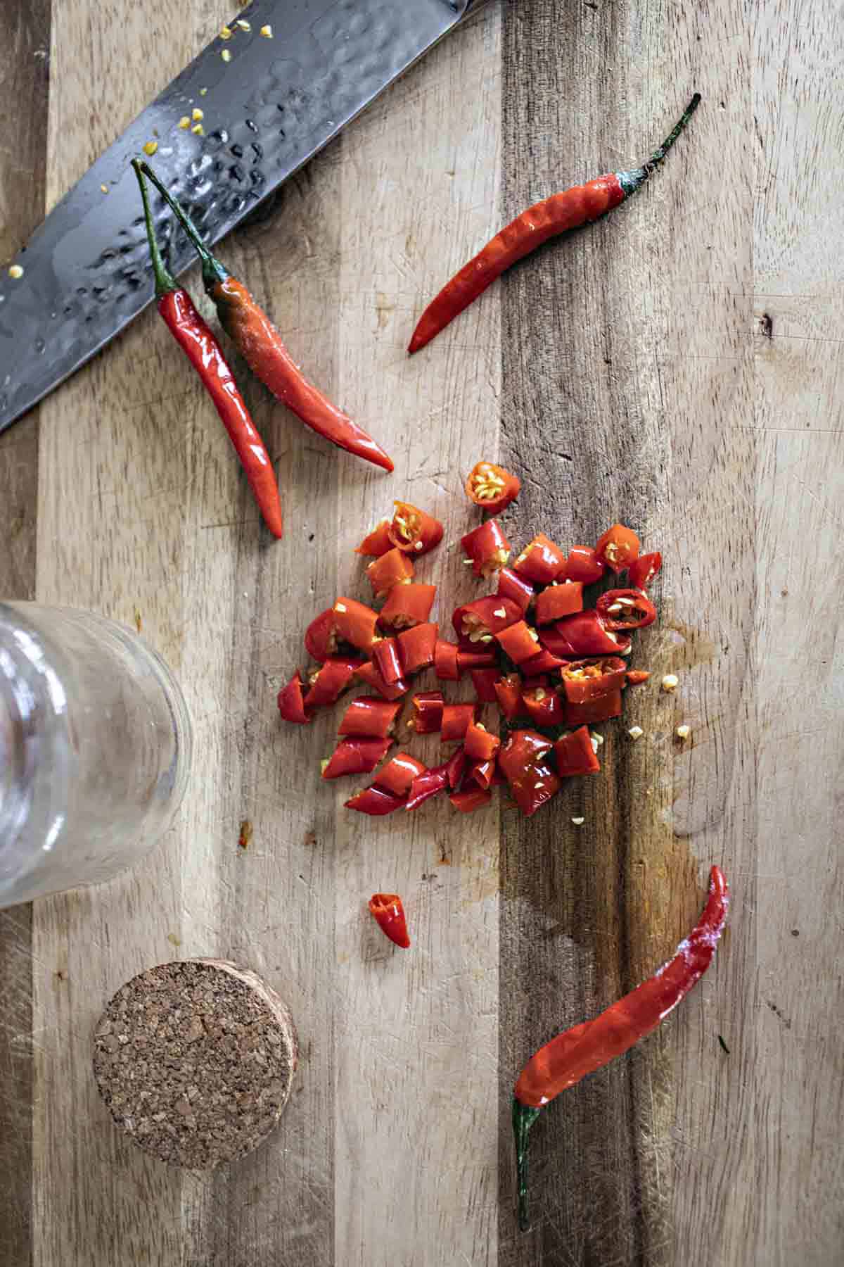 Chopped Thai red chilis  on cutting board for making Prik Nam Som. 