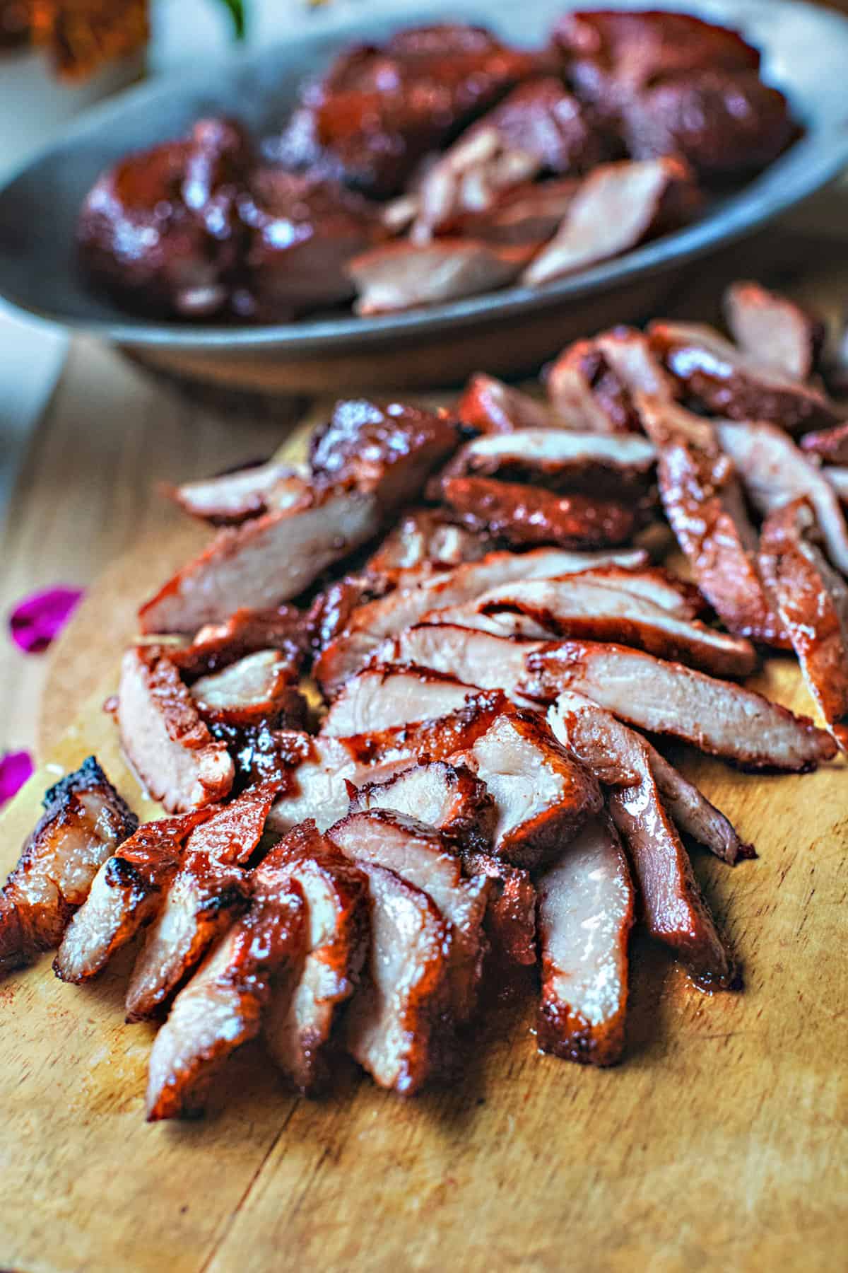 char siew red pork slices on a cutting board. 