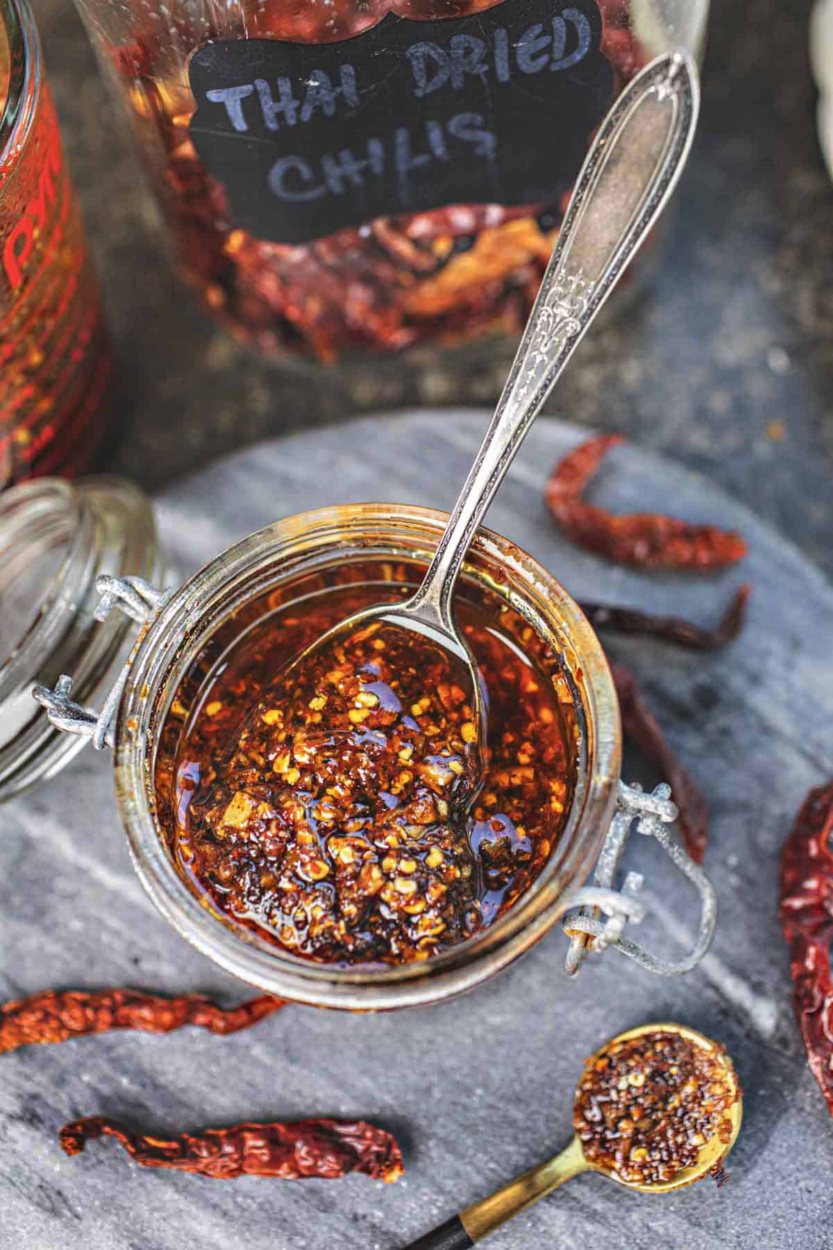 Thai Chili oil in a jar with a spoon in the middle. 