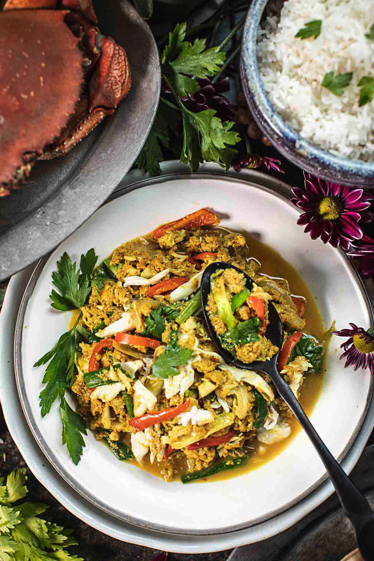 Pad Pong Karee -Crab stir fry on a plate with a spoon on top. 