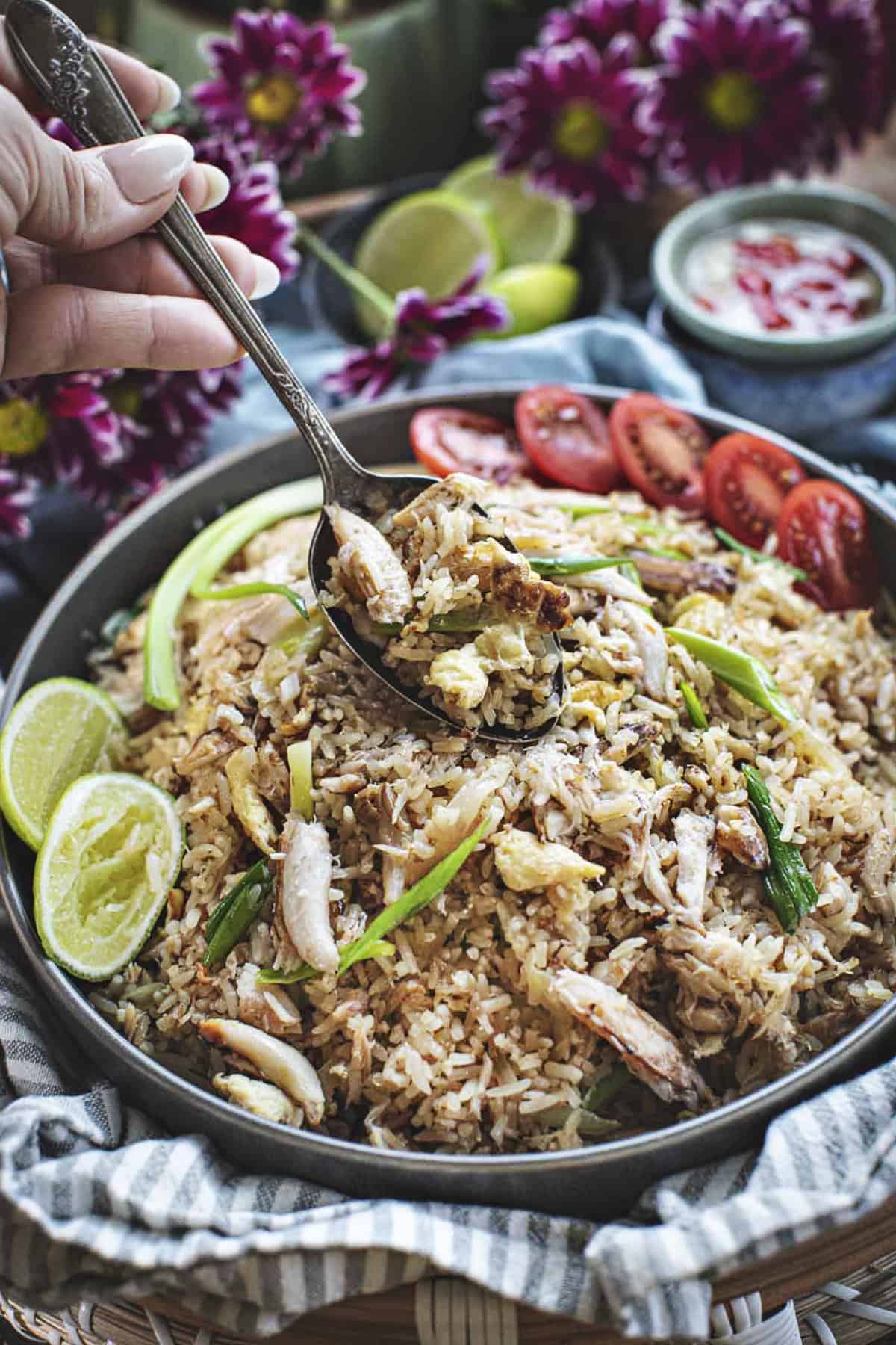 A spoon lifting Thai crab fried rice from a plate