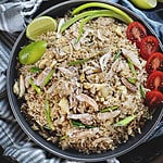 crab fried rice on a plate with tomato and cucumber slices.