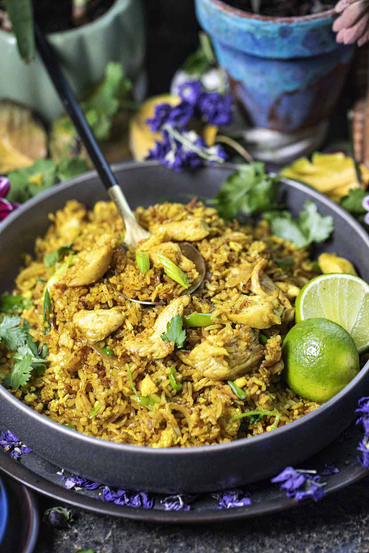 Yellow fried rice recipe in a bowl with a spoon on the table.