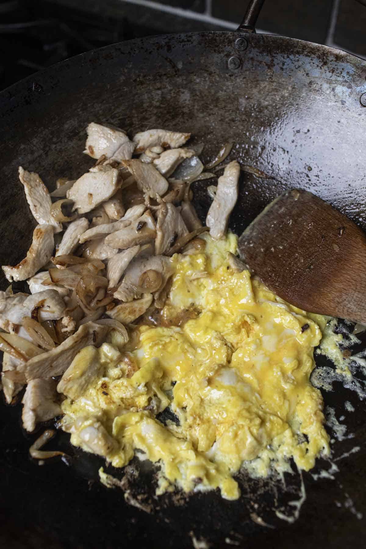 scrambled eggs with chicken in a wok. 