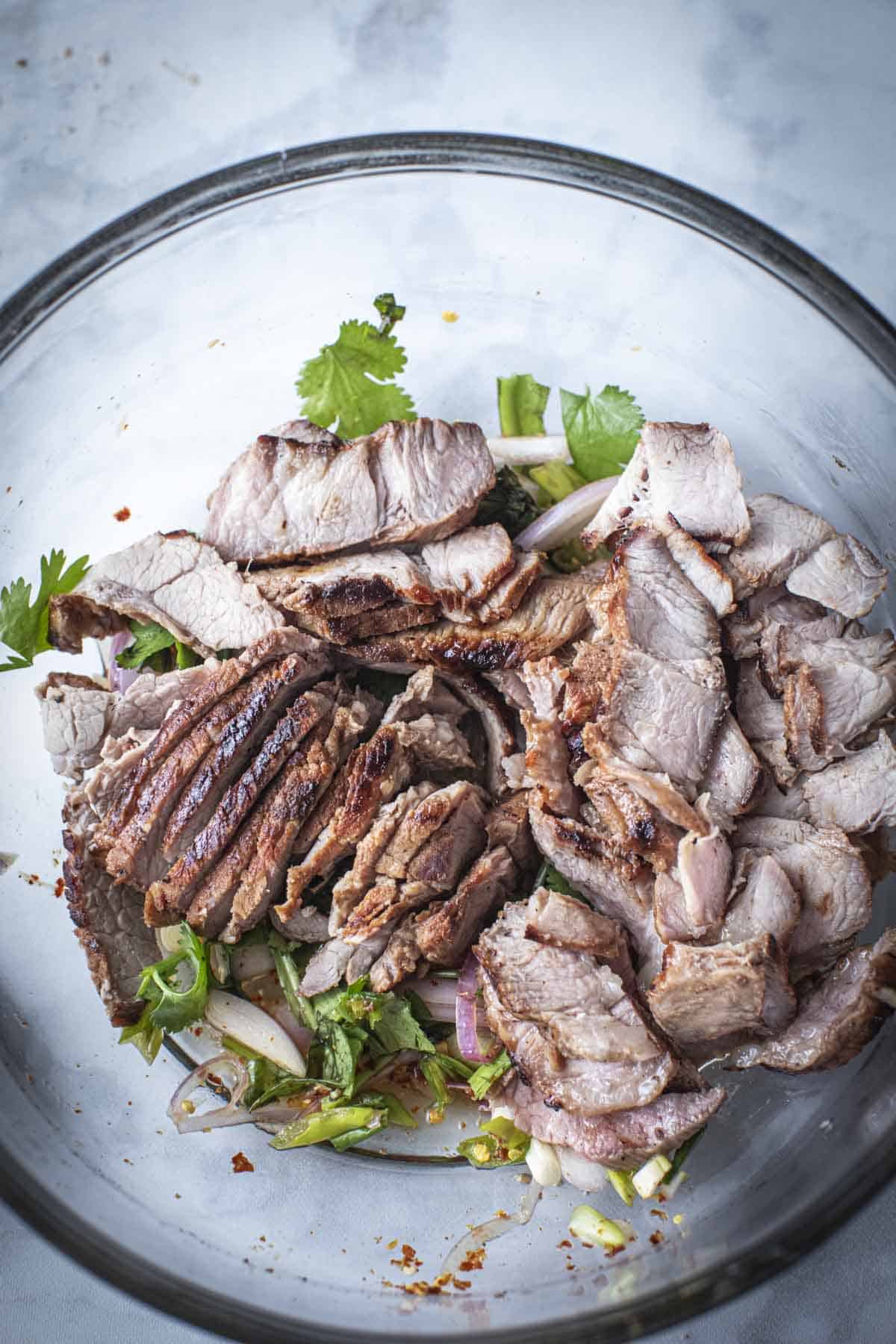 Grilled Pork slices on a salad in a bowl. 