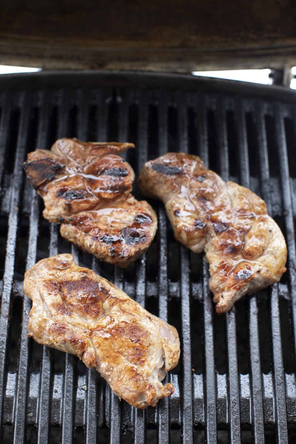 Grilled pork meat on a grill.