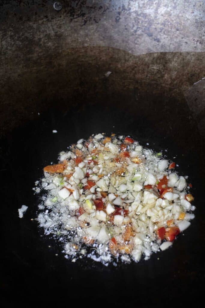 garlic and peppers frying in a wok.