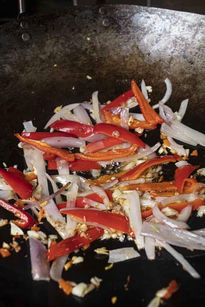 Red Pepper and shallot frying in a wok.