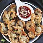 Beef Wontons on a plate with dipping sauce.