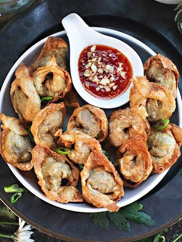 Beef Wontons on a plate with dipping sauce.