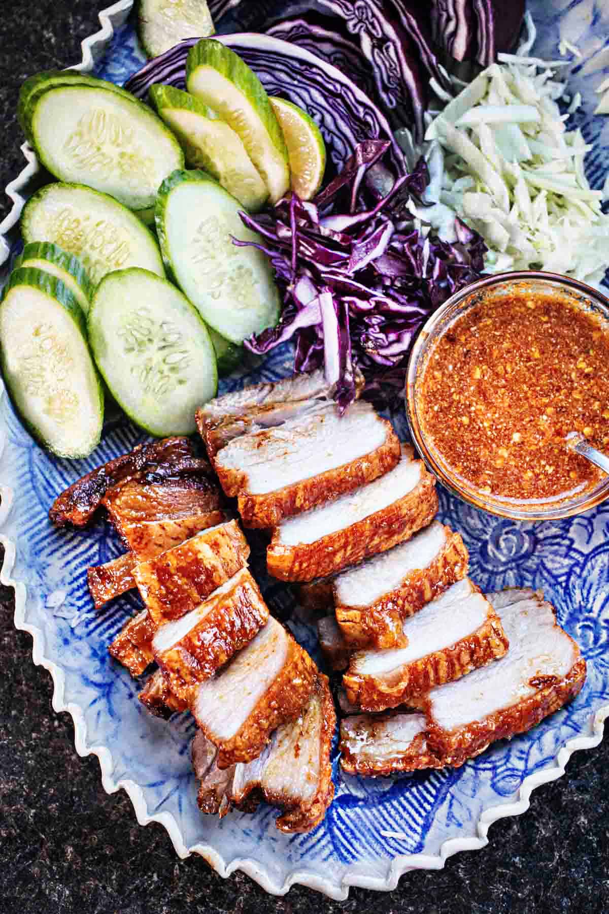 Chinese five spice pork belly slices with chili sauce and cucumber slices. 