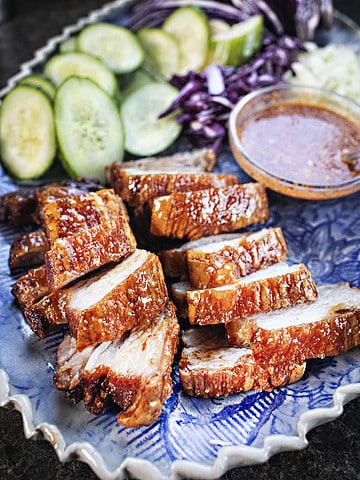 Crispy chinese pork belly slices on a plate.