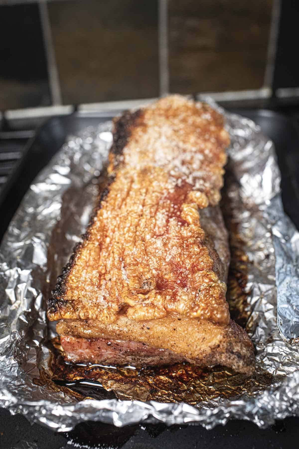 Cooked pork belly on foil. 