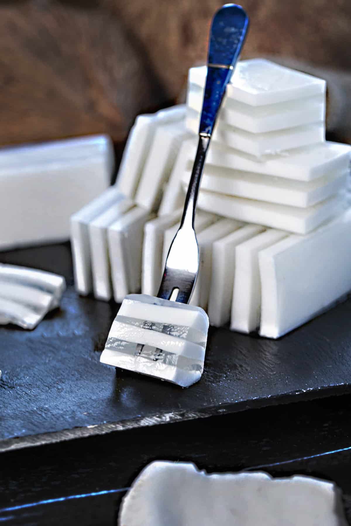 A fork lifting Coconut jelly dessert on a tray.