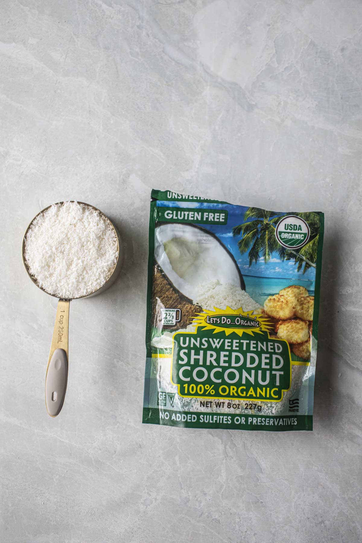 Shredded coconut flakes in a bag with measuring cup. 