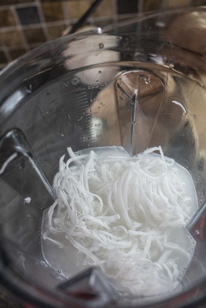 Shredded coconut in a food processor. 