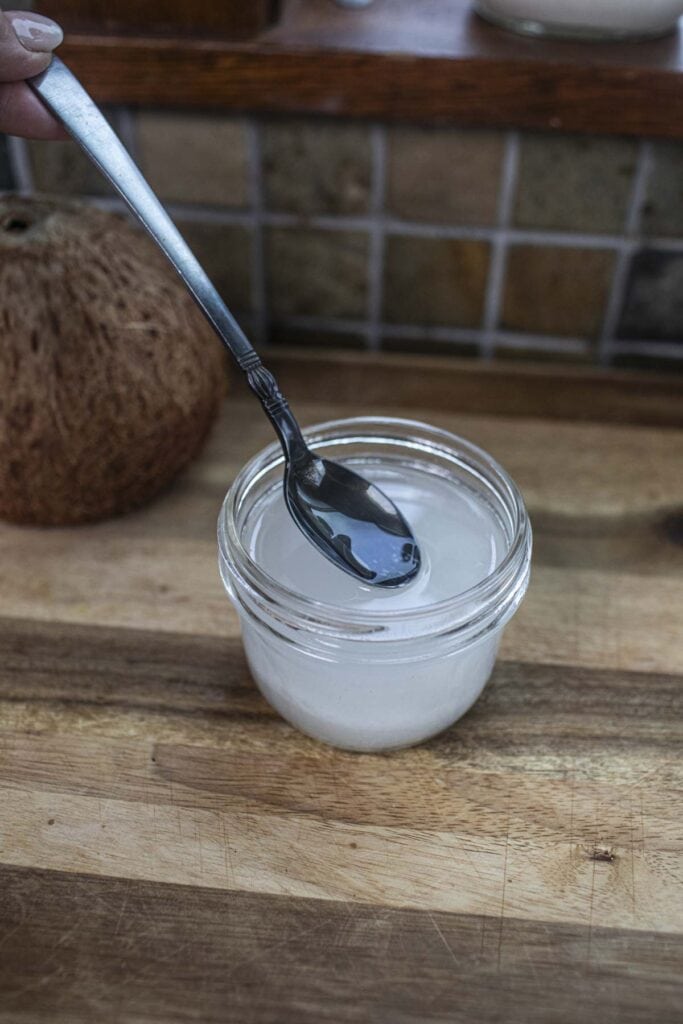 coconut buter in a glass jar with a spoon. 