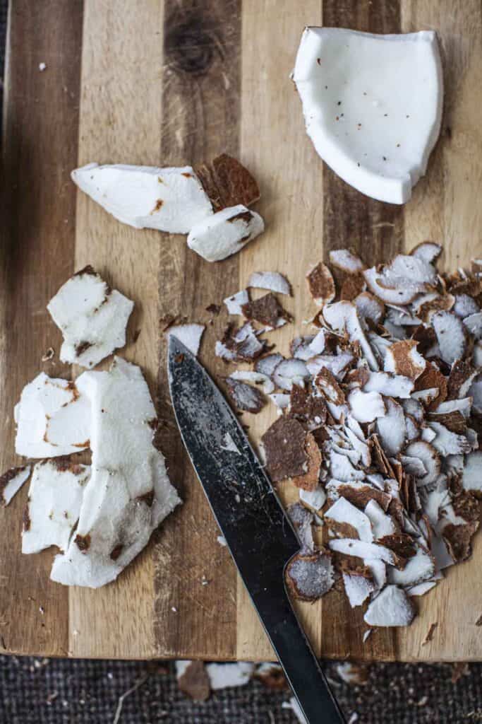 Peeled Coconut skin from coconut meal on the cutting board. 