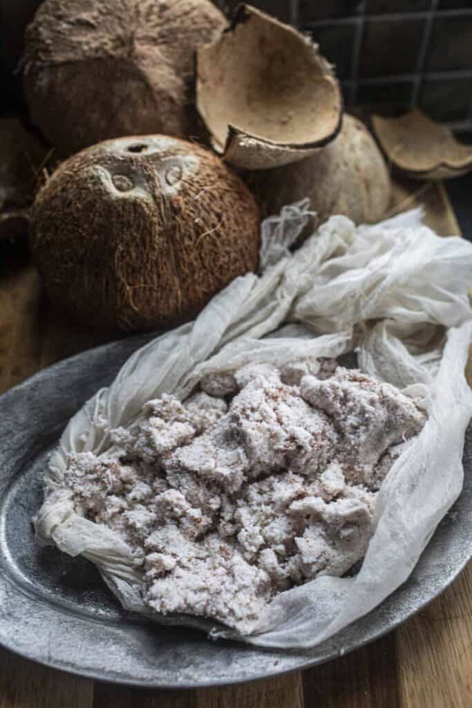 Coconut pulp in a cheesecloth on a plate.